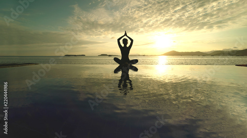 Unknown woman meditating on the beach © Creativa Images