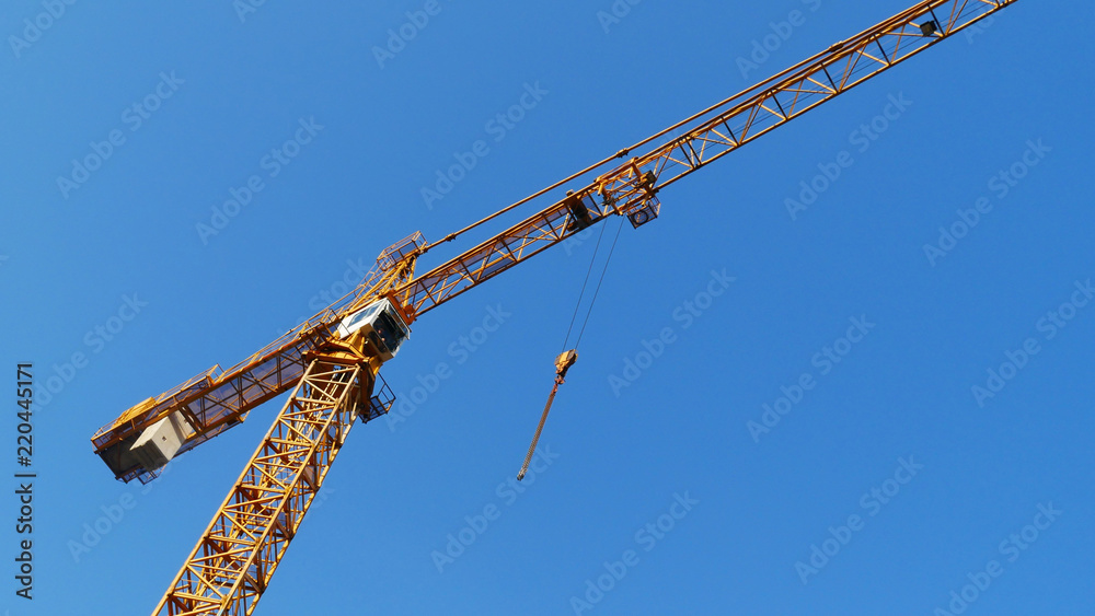 Huge crane against blue sky. Industrial crane. Hoisting crane. Construction site. Huge crane against blue sky. Industrial crane. Hoisting crane. Construction site.