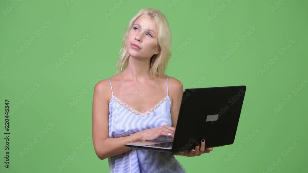 Young happy beautiful businesswoman thinking while using laptop Young happy beautiful businesswoman thinking while using laptop