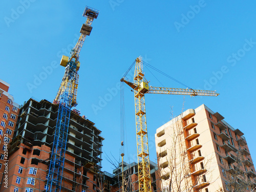 Construction site background. Two industrial cranes near buildings.Commercial construction project.