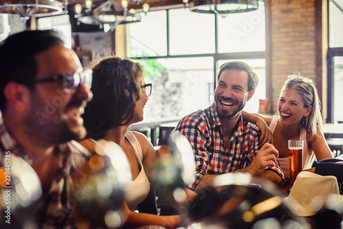 Canvas Print Happy friends having fun at bar - Young trendy people drinking beer and laughing