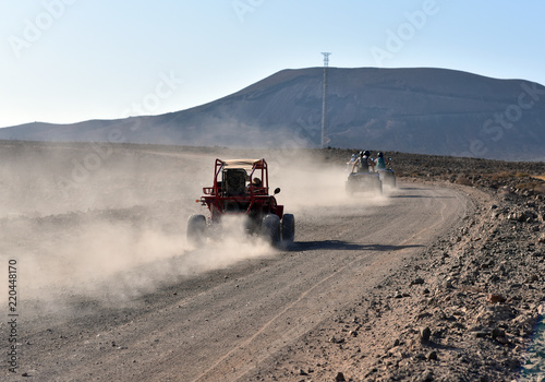 Fuerteventura, Canary Islands, North Africa, Spain: a dune buggy on the dirt and winding road on the cliff to Playa de Cofete beach