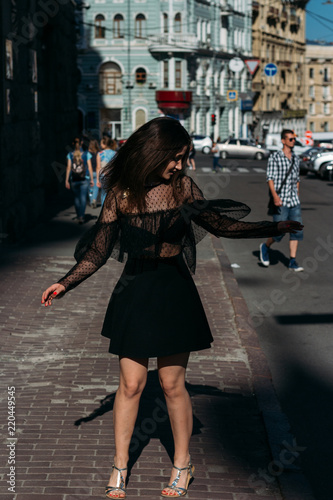 beautiful brunette whirls , dances on a street in the middle of the city, laughs, smiles, happiness,fun © Skripnik Olga