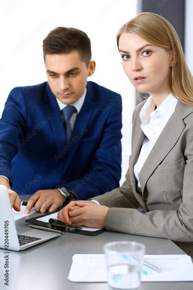 Business people using laptop pc while discussing project in office Business people using laptop pc while discussing project in office