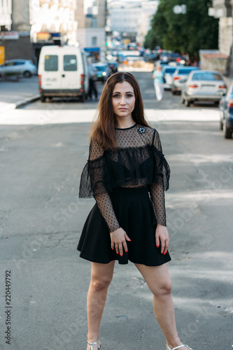 Emotional portrait of Fashion stylish portrait of pretty young woman. city portrait. sad girl. brunette in a black dress with stars and planets on a dress. expectation. dreams. girl - night in the