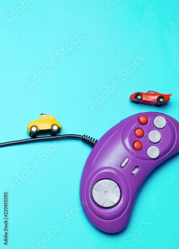 Retro Computer Gaming Controller And Small Race Cars On The Blue Background Top View Space For Text Minimal Style