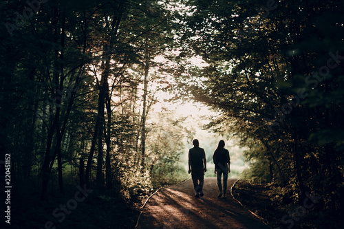 Young adult pair. Man and woman go through the forest together.