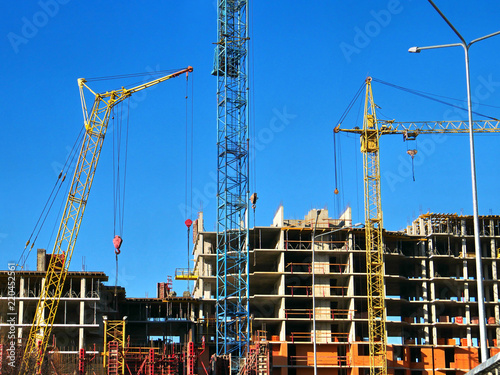 Crane. Crane and building against blue sky. Construction site background. © fotolian121212