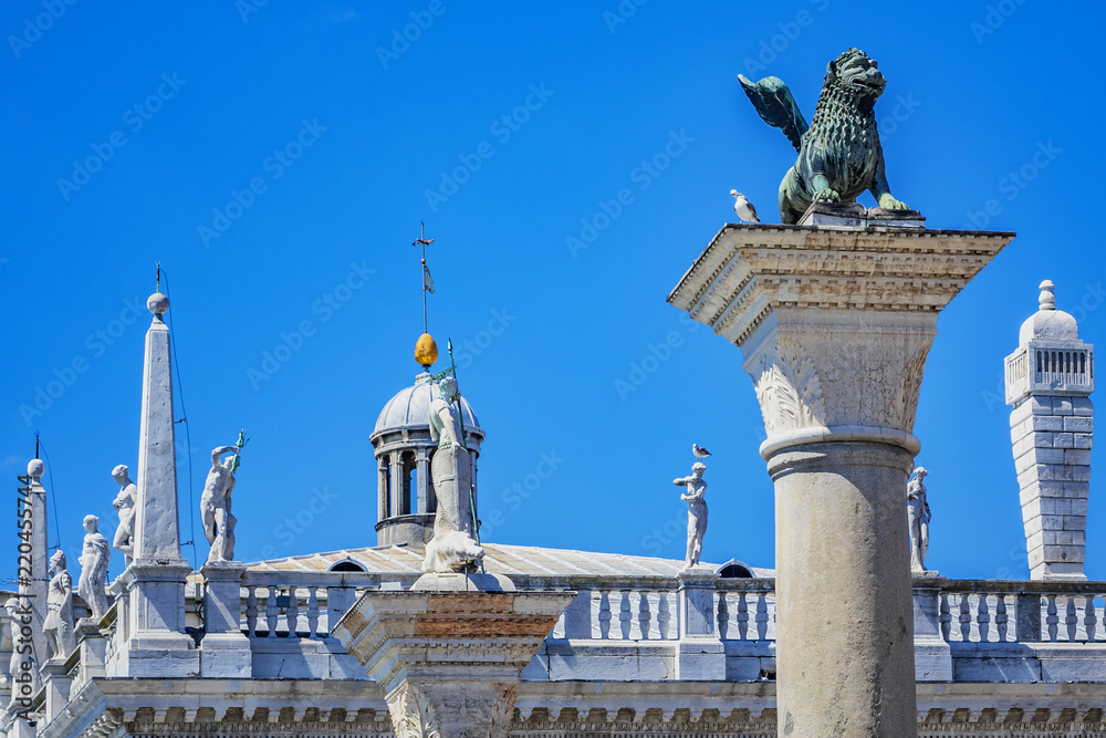 Lion of Venice at Ancient column (1268), bronze winged lion sculpture in the Piazza San Marco - the symbol of Venice city. Venice, Italy. Venice - UNESCO world heritage Site.