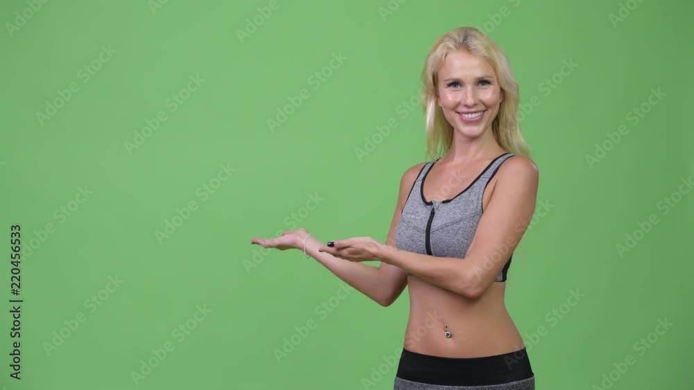 Young happy beautiful woman showing something ready for gym Young happy beautiful woman showing something ready for gym