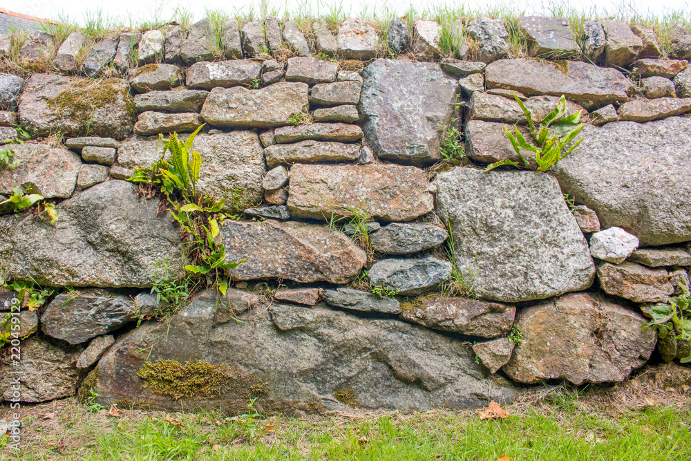 Hintergrund – bewachsene Natursteinmauer
