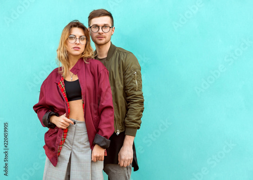 fashion couple standing posing near blue wall