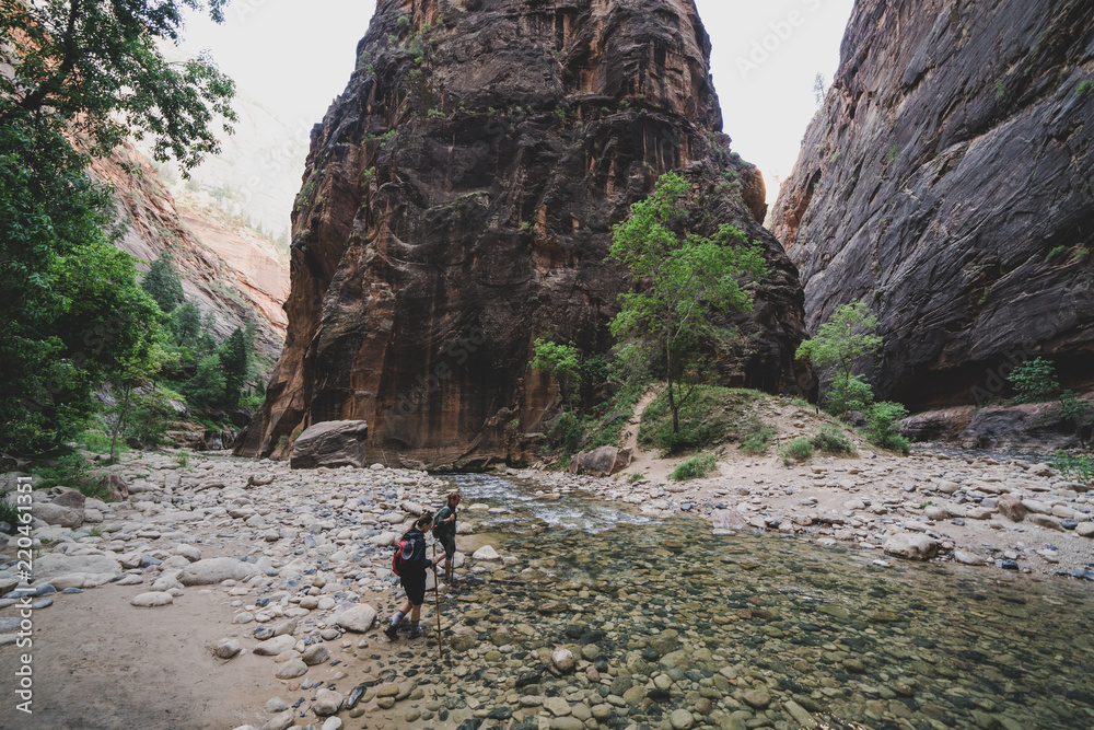 Two Young Female Friends Hiking Through the Narrows, Zion National Park, Utah - USA