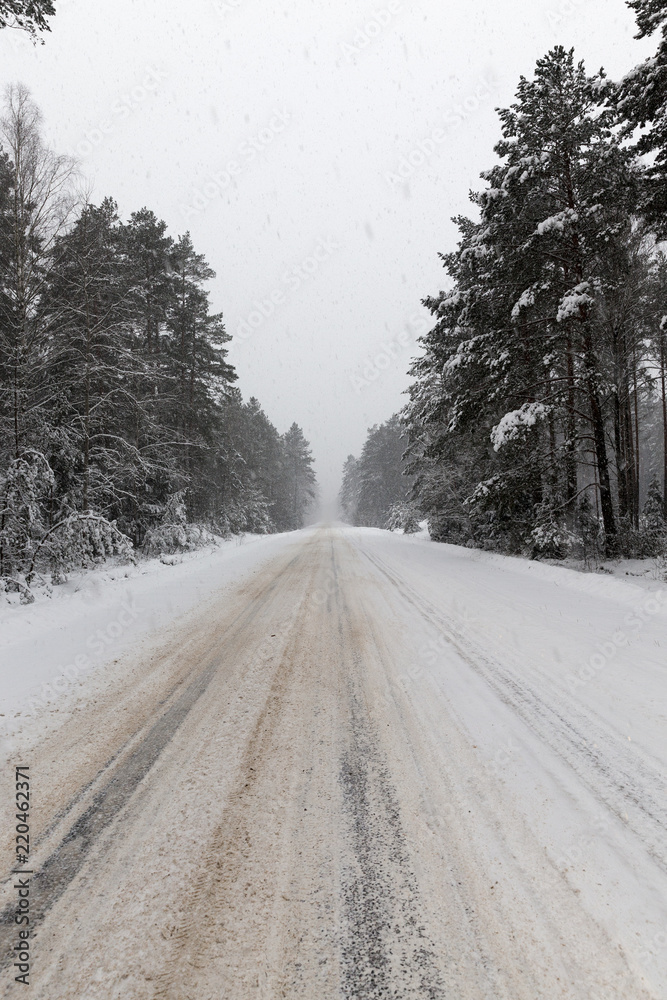 a dirty, broken snow-covered road