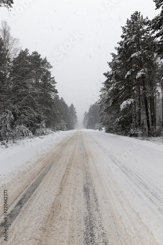 a dirty, broken snow-covered road © rsooll