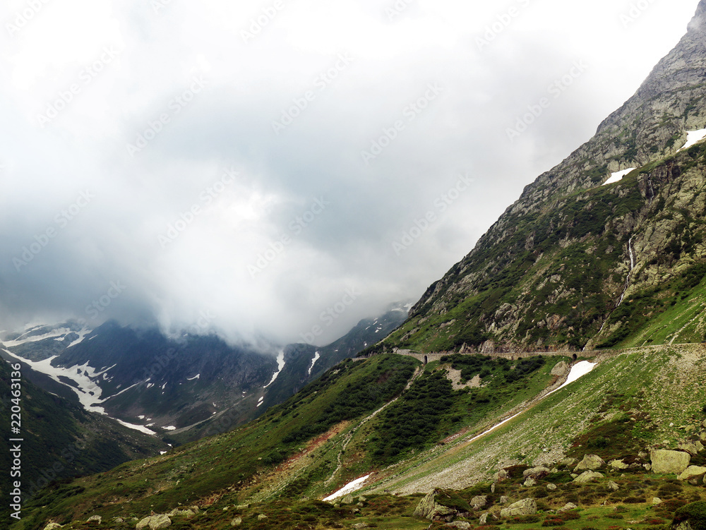 Winding roads in the Alps. The road lead through the clouds whos hanging just above in Switzerland (Susten Pass).
