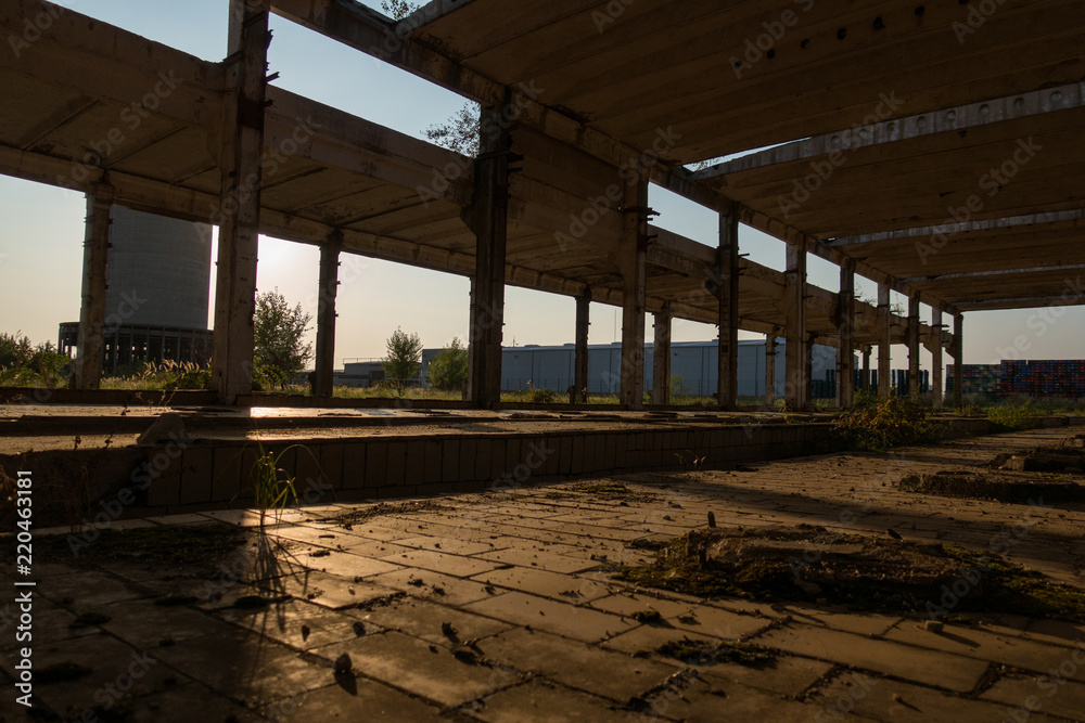 A deserted industrial plant site with old deserted structure on a beautiful sunset.