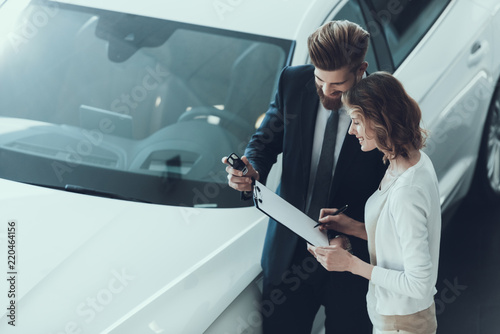 Car Salesman Consultant Showing Contract to Woman photo