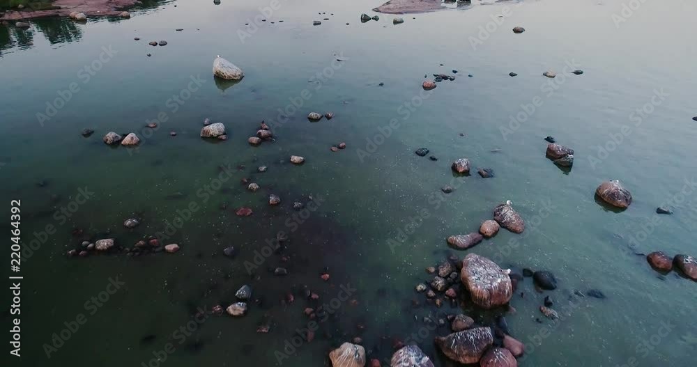 Flying over water with rocks, cliffs and seagulls on an evening Flying over water with rocks, cliffs and seagulls on an evening