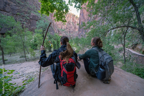 Two Young Female Friends Hiking Through the Narrows, Zion National Park, Utah - USA