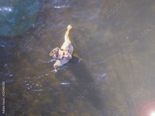 top view of young man walk in the sea water on the beachon summer resort photo