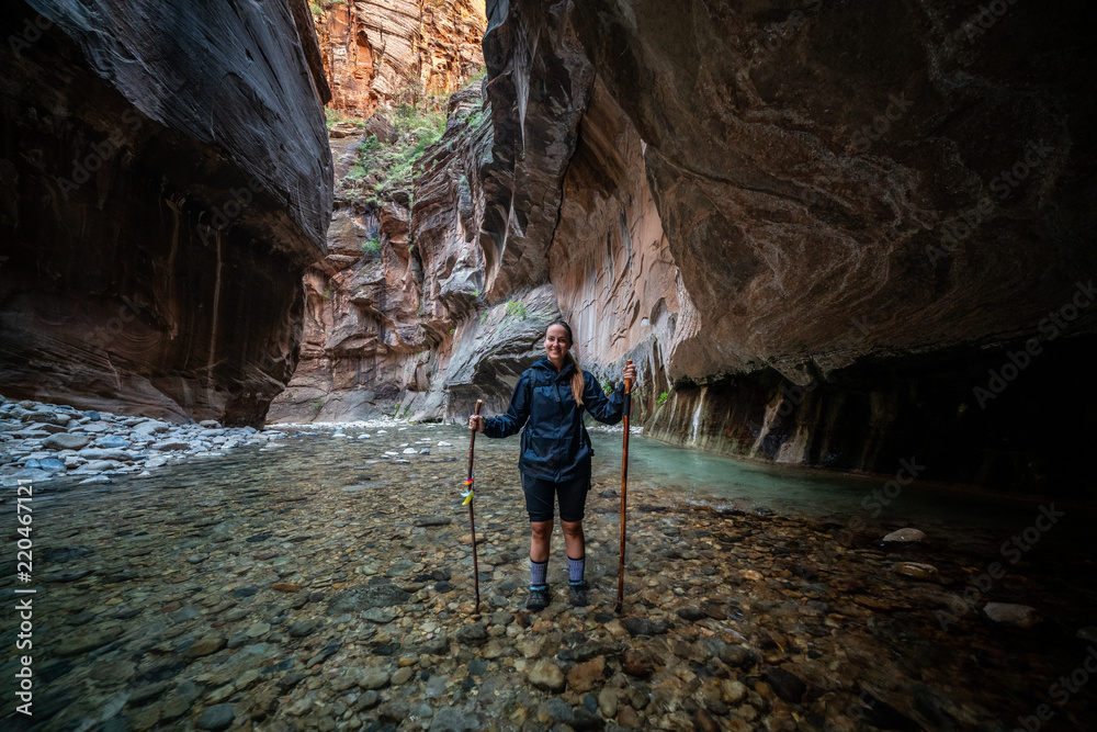Obraz premium Young Female Hiking Through the Narrows, Zion National Park - USA