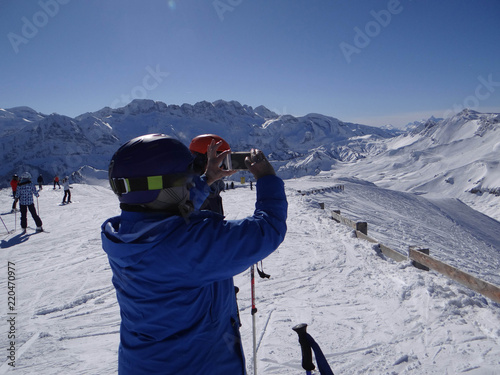 Skiers take photos in the Swisss alps photo