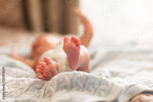 newborn baby legs close-up on the bed in the bedroom