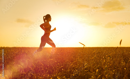 Sporty woman at sunset in wheat field
