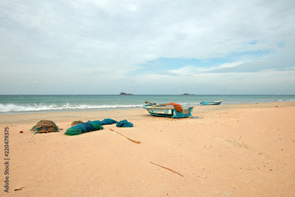 Nets, baskets, and ropes next to fishing boat on Nilaveli beach in Trincomalee Sri Lanka Nets, baskets, and ropes next to fishing boat on Nilaveli beach in Trincomalee Sri Lanka