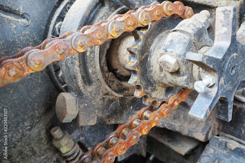 Chain drive. Rusty driving roller chain on the drive sprocket in operation
