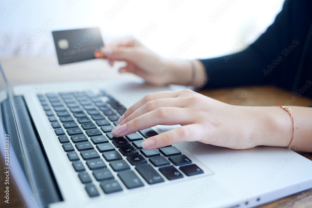 female hands holding credit card and using laptop for online shopping female hands holding credit card and using laptop for online shopping