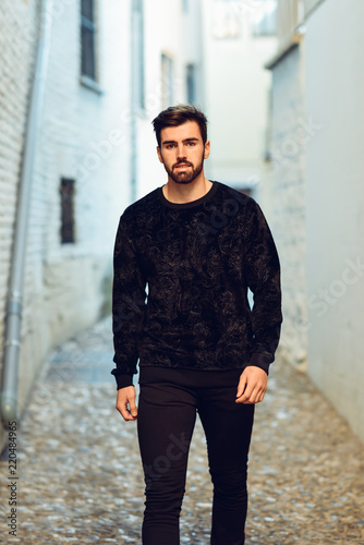 Young bearded man, model of fashion, in urban background wearing casual clothes.