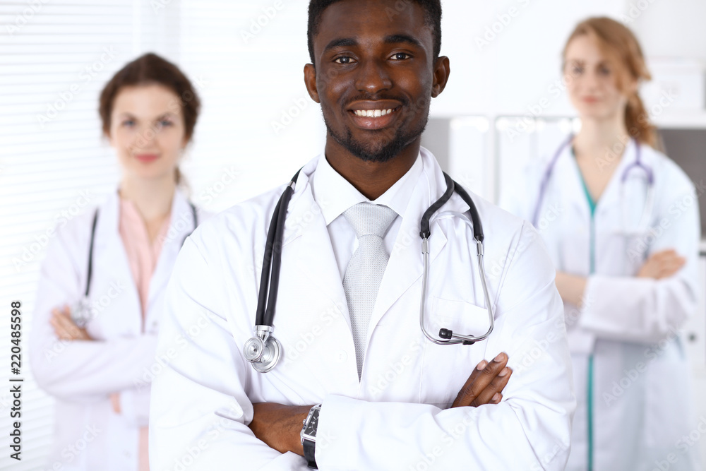 Happy african american male doctor with medical staff at the hospital. Medicine concept Happy african american male doctor with medical staff at the hospital. Medicine concept