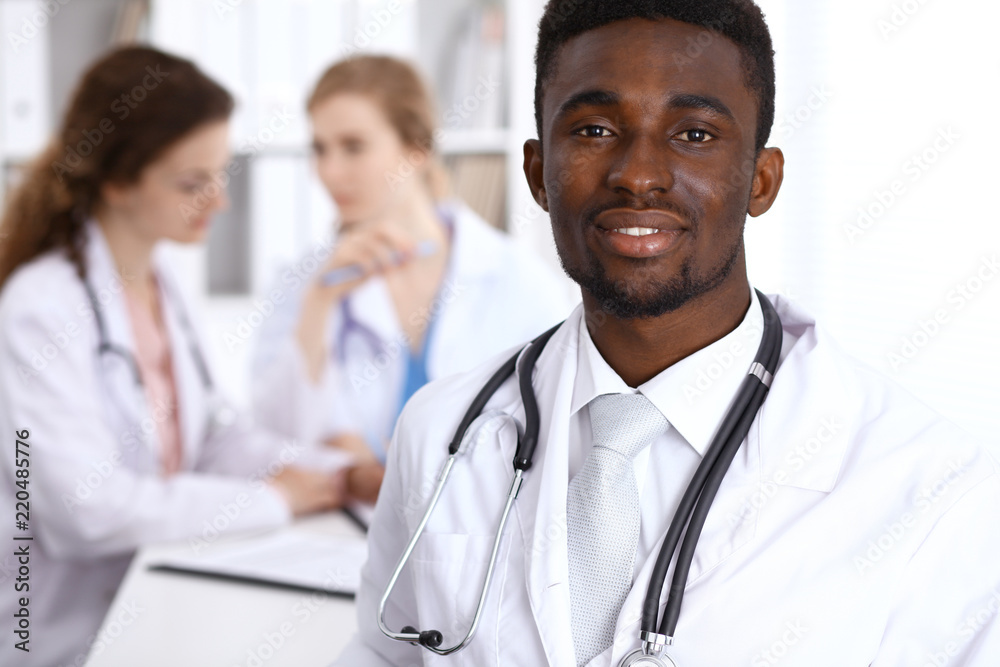 Happy african american male doctor with medical staff at the hospital. Medicine concept Happy african american male doctor with medical staff at the hospital. Medicine concept
