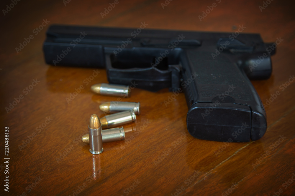 .38 mm handgun and bullets strewn on the rustic wooden table background. Gun with ammunition on wooden background and Isolated Gun and ammo.