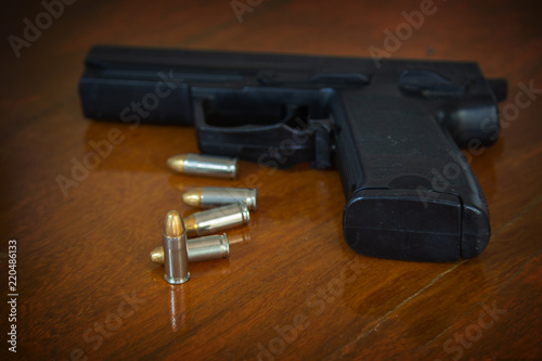 .38 mm handgun and bullets strewn on the rustic wooden table background. Gun with ammunition on wooden background and Isolated Gun and ammo.