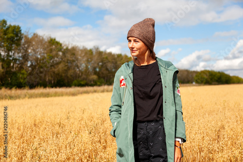 Outdoor fashion photo of young beautiful woman in golden field in warm autumn winter. Cozy autumn coat © Виталий Сова