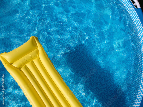 Top view of an inflatable mattress in a backyard swimming pool