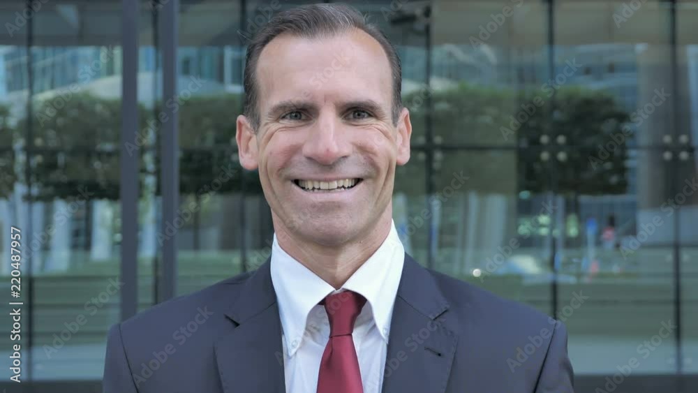 Portrait of Smiling Middle Aged Businessman Looking at Camera Portrait of Smiling Middle Aged Businessman Looking at Camera