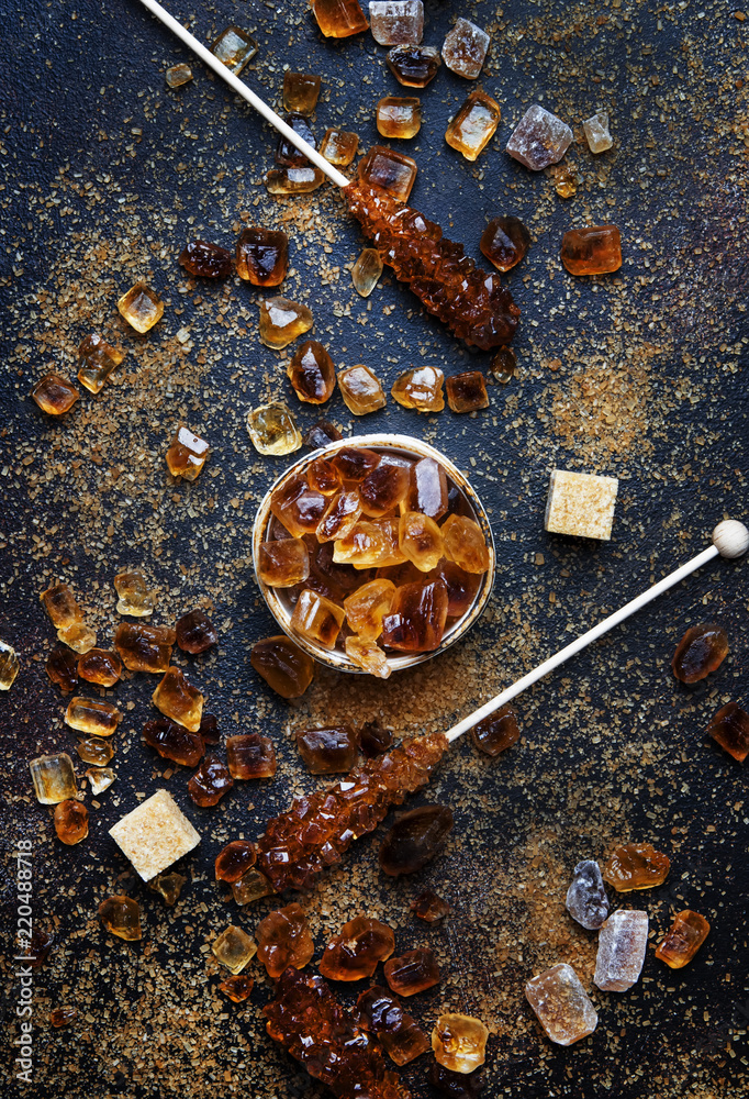 Sweet food background, assorted white and brown sugar on a dark background, top view Sweet food background, assorted white and brown sugar on a dark background, top view