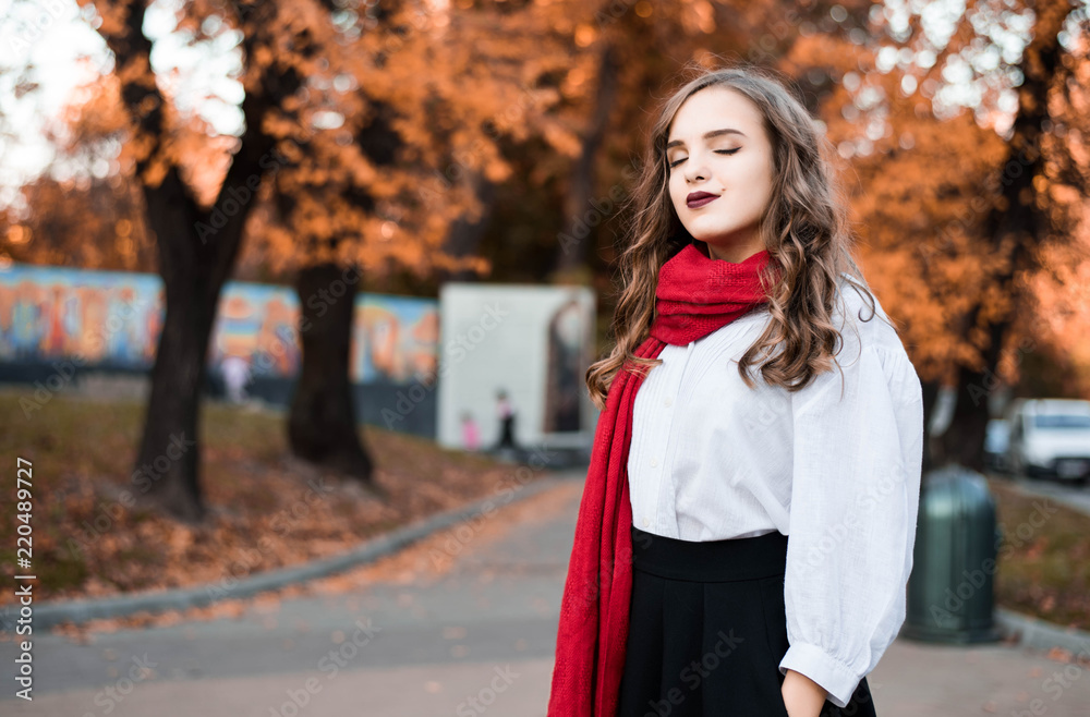 Street portrait of young beautiful woman wearing stylish classic clothes. Model looking up. Female fashion concept. French style. Parisian woman in old fashioned red scarf. Street portrait of young beautiful woman wearing stylish classic clothes. Model looking up. Female fashion concept. French style. Parisian woman in old fashioned red scarf.