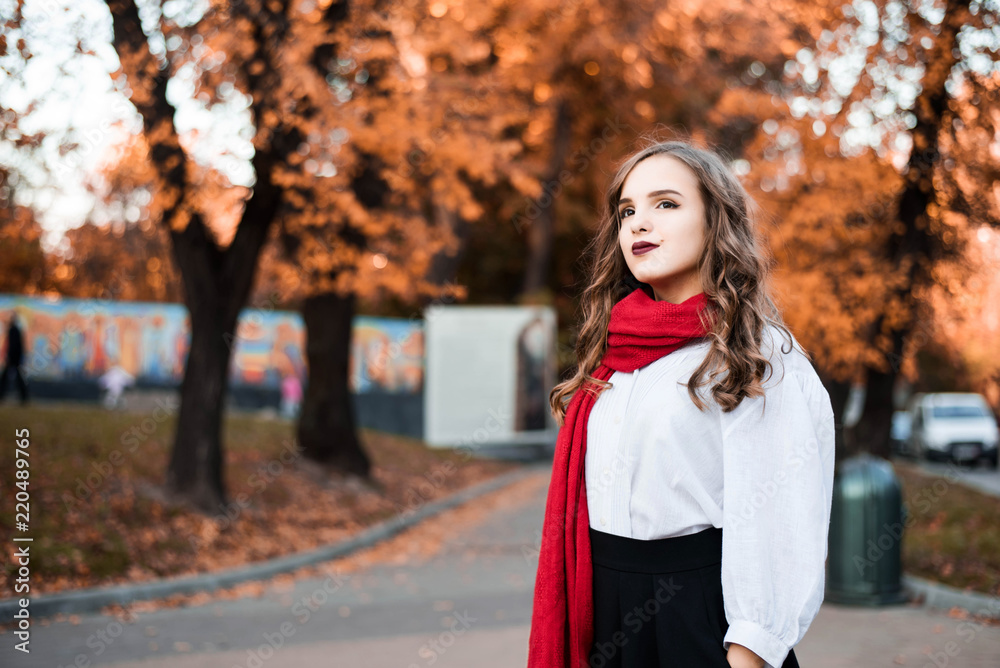Street portrait of young beautiful woman wearing stylish classic clothes.  Model looking up. Female fashion concept. French style. Parisian woman in old  fashioned red scarf. Stock Photo