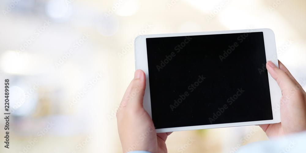 Businessman hand holding tablet with blank on screen display over blur background, business people and technology display montage, mock up, template, background Businessman hand holding tablet with blank on screen display over blur background, business people and technology display montage, mock up, template, background