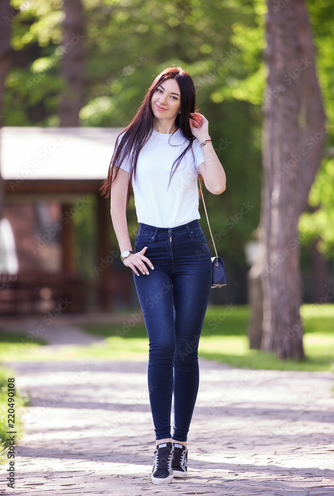 Pardon Zielig gangpad Portrait of beautiful happy stylish woman in blue jeans and white t-shirt,  walking on the street. Fashion woman lifestyle. Woman style, trendy outfit  Stock Photo | Adobe Stock