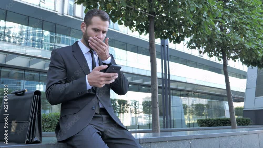 Shocked, Businessman Astonished by Using Smartphone Shocked, Businessman Astonished by Using Smartphone