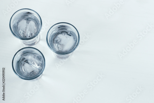 Vodka shots with ice on a white background