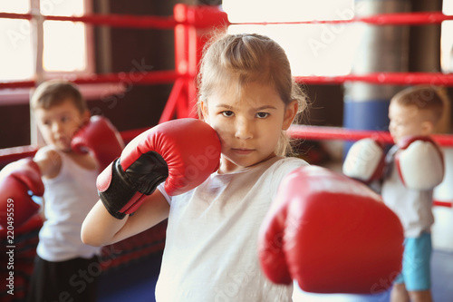 Little girl in boxing gloves on ring © Africa Studio