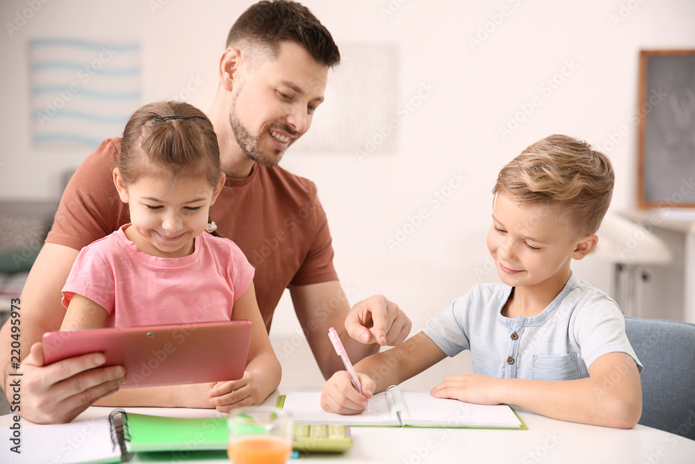 Cute little children doing homework with father Cute little children doing homework with father
