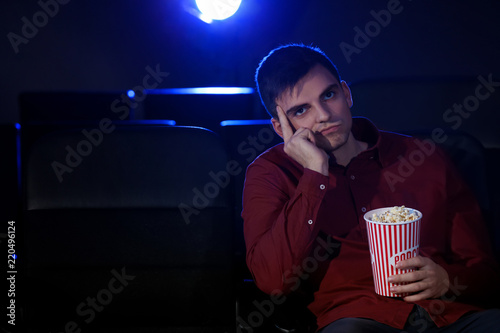 Young man watching movie in...